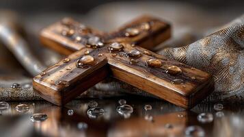 Wooden cross adorned with water droplets on fabric during a serene indoor setting in the morning light photo
