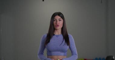 Sporty girl announcer speaks directly into camera in a bright indoor setting during an athletic event video