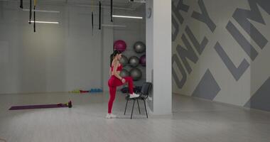 Stepping onto a chair during a dynamic workout session in a modern fitness studio environment video
