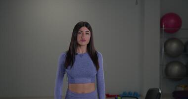 Sporty girl announcer engages the audience while presenting fitness tips in a gym setting video