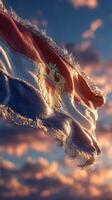 Flag of a nation waving in the wind at sunset with dramatic clouds in the background photo