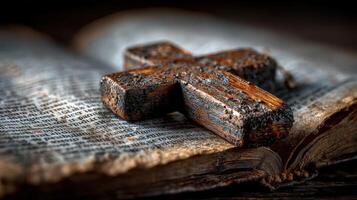 Wooden cross resting on an antique book with weathered pages and faded text photo
