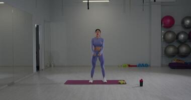 Athletic girl performs dynamic arm swings during a workout session in a bright fitness studio video
