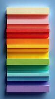 Colorful stacked blocks create a vibrant display of pastel shades arranged in a gradient on a blue background photo