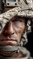 Soldier saluting with a somber expression during a military event at sunset in a rugged environment photo