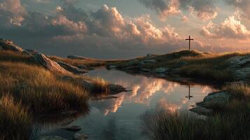 Sunset over a tranquil pond with a cross and vibrant clouds in a grassy landscape photo