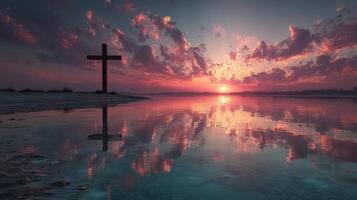 Sunset reflection over water with cross silhouette in serene landscape at dusk photo