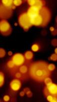 Glowing yellow particles float across a dark background in a vibrant bokeh-style abstract scene video