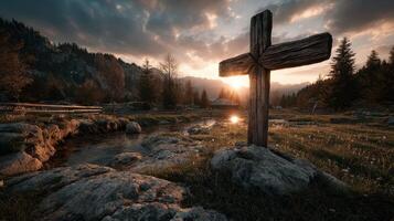 Sunset over a tranquil meadow with a wooden cross near a stream in the mountains photo