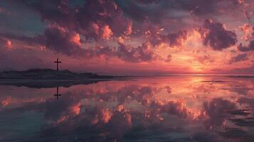 Sunset reflections over calm water with cross silhouette on the shore photo