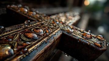 Detailed view of an ornate wooden cross adorned with raindrops in a serene outdoor setting during twilight photo