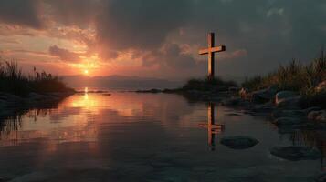 Sunset over a tranquil lake with a wooden cross reflecting in the water along a serene landscape photo