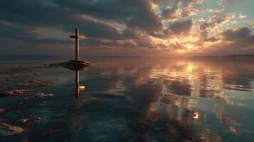 Serenity at dawn with a cross reflecting in calm waters under a colorful sky photo