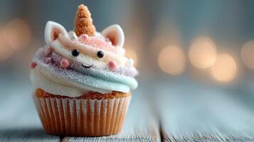 Colorful unicorn cupcake with sprinkles and a cute smile placed on wooden surface photo
