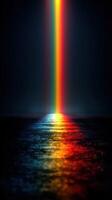 Colorful spectrum of light illuminating a dark water surface at night photo
