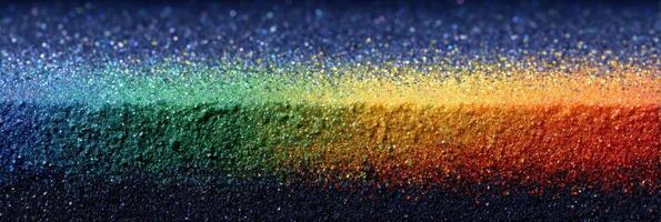 Vibrant rainbow spectrum of glittery particles creating a striking visual display across a dark background photo
