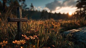 Wooden cross in a meadow during sunset with flowers and tall grass surrounding it photo