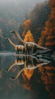 Dinosaurs wander near a tranquil lake surrounded by autumn trees at dawn photo