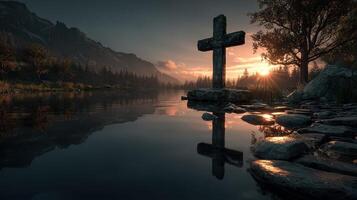 Reflection of a stone cross at sunset by a calm lake surrounded by mountains and trees photo