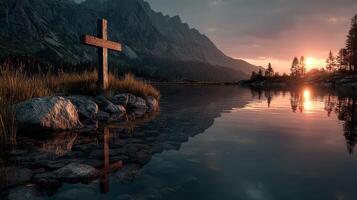 Serene lake sunset with wooden cross reflection and majestic mountains in the background photo