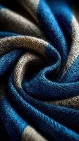 Textured blue and beige fabric forming elegant swirling pattern in close-up view photo