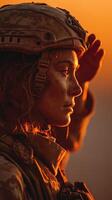 Soldier saluting at sunset with warm orange hues illuminating the serene moment of respect and reflection photo