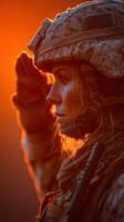 Military service member saluting at sunset in a dramatic display of respect and honor photo