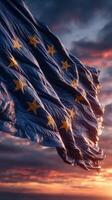 European Union flag waves against a dramatic sunset sky with clouds and vibrant colors photo