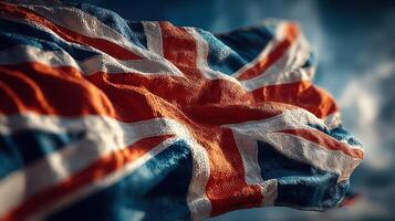 A vibrant British flag can be seen waving in the breeze under a clear blue sky during daylight photo