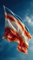Vibrant flag of Costa Rica waving against a clear blue sky in a sunny atmosphere photo