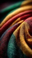 Vibrant textile fabric in rich red, green, and gold, showcasing intricate woven patterns in a bright daytime setting photo