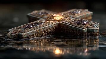 Intricate cross design resting on reflective surface during warm, ambient lighting photo