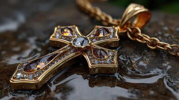Intricate golden cross necklace resting on a wet stone surface under soft natural light photo