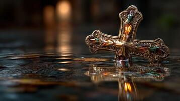 Golden cross resting on blurred water surface in a serene environment at dusk photo