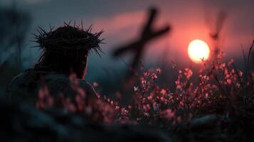 Sunset silhouette of a figure wearing a crown of thorns in a field of flowers during a tranquil evening moment photo