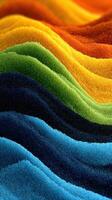 Colorful sand patterns create a wave-like texture in brilliant hues, showcasing nature's beauty through vibrant colors and serene movement photo