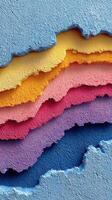 Colorful layers of textured wall paint peeling in various shades during daylight hours photo