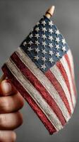 Small hand-held American flag in a close-up shot showcasing the intricate fabric details and vibrant colors photo