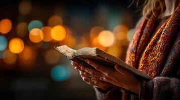 Holding an ancient book surrounded by warm lights on a quiet evening photo