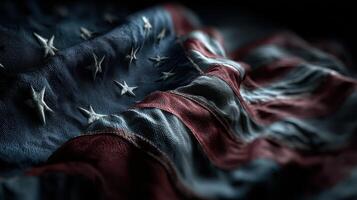 Waving cloth displaying a weathered American flag in a dark background highlighting its texture and colors photo