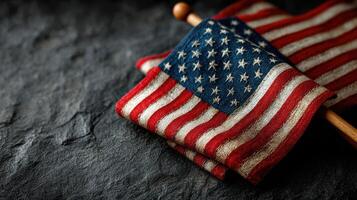 American flag displayed on a dark stone surface showcasing its vivid colors and texture in a patriotic setting photo