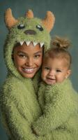 Smiling woman and baby wearing matching green monster costumes pose happily in a cozy indoor setting photo