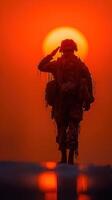 Soldier saluting as the sun sets over a distant horizon in a moment of reflection and respect photo