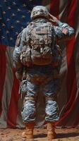 Soldier saluting in front of a large American flag during a solemn moment of tribute and respect photo