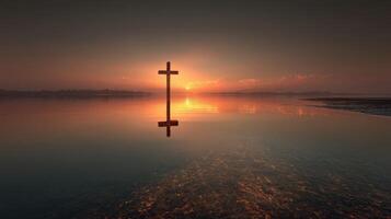Sunrise reflection on water with a cross silhouetted against the horizon in a tranquil setting photo