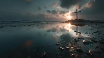 Reflective cross by the seaside at dawn under dramatic sky photo