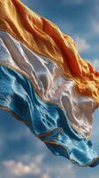 National flag billowing in the wind against a bright blue sky during a sunny midday photo