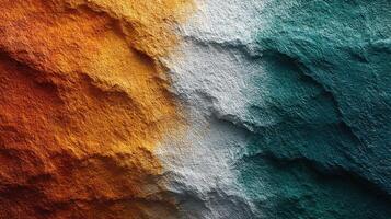 Vivid textured wall surface displaying shades of orange, white, and teal in an artistic blend photo