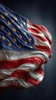United States flag waving against a dark background with prominent details highlighting its stars and stripes photo