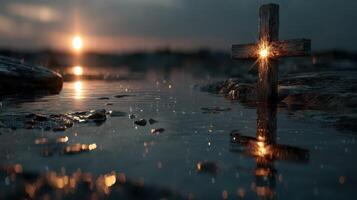Cross illuminated on wet rocks at sunset, reflecting in tranquil water with a glowing atmosphere photo